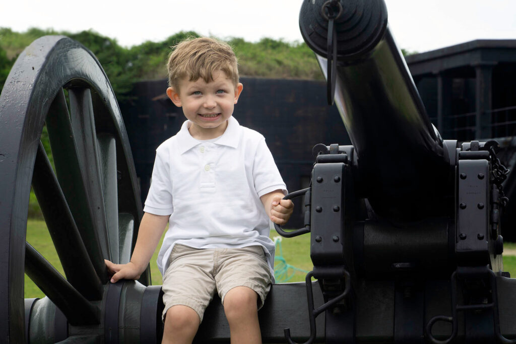boy sitting on cannon at fort pickens