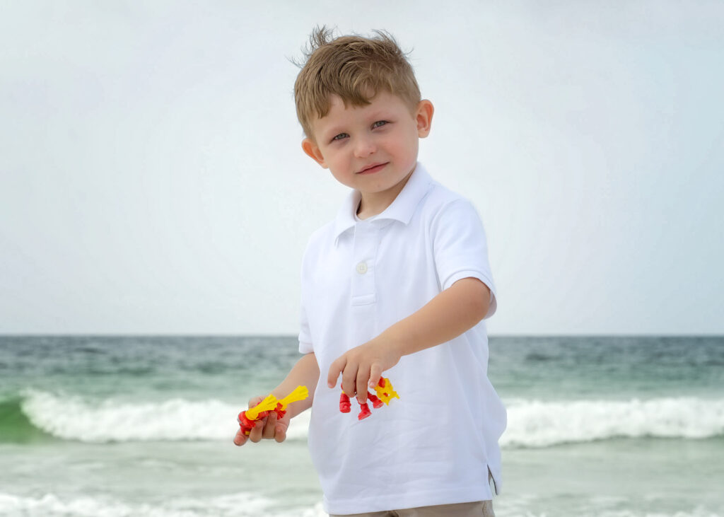 boy with toys on beach