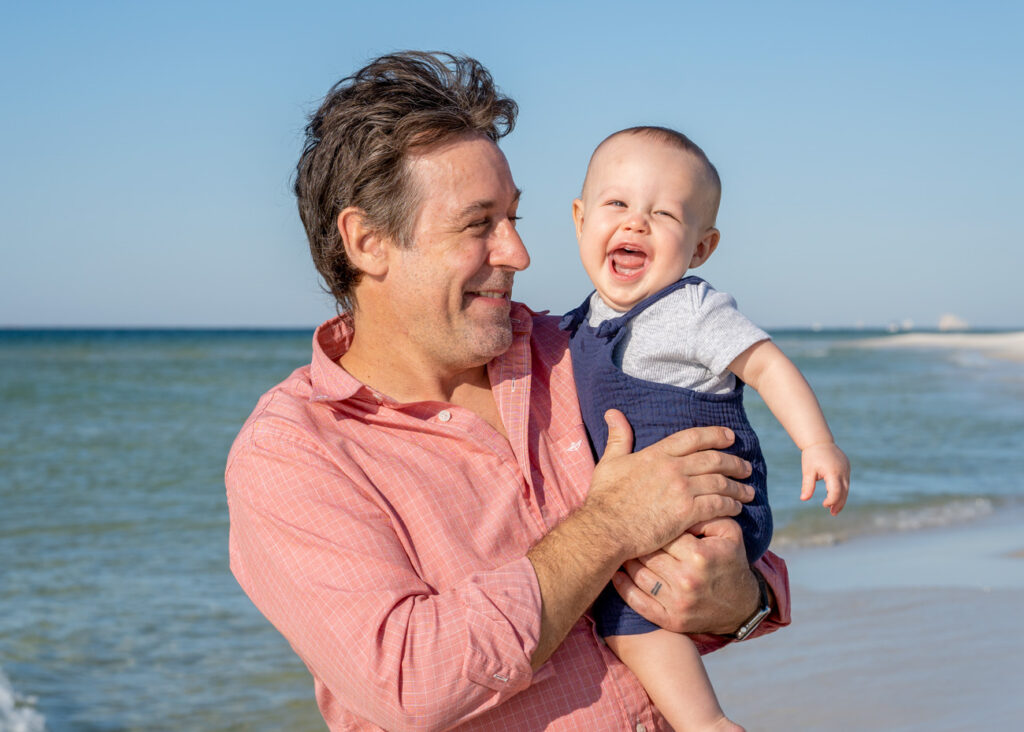 father and infant son on beach