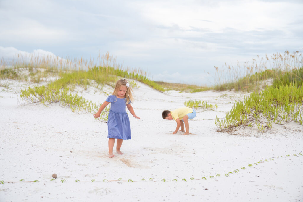 Two children playing in the sand on a beach.