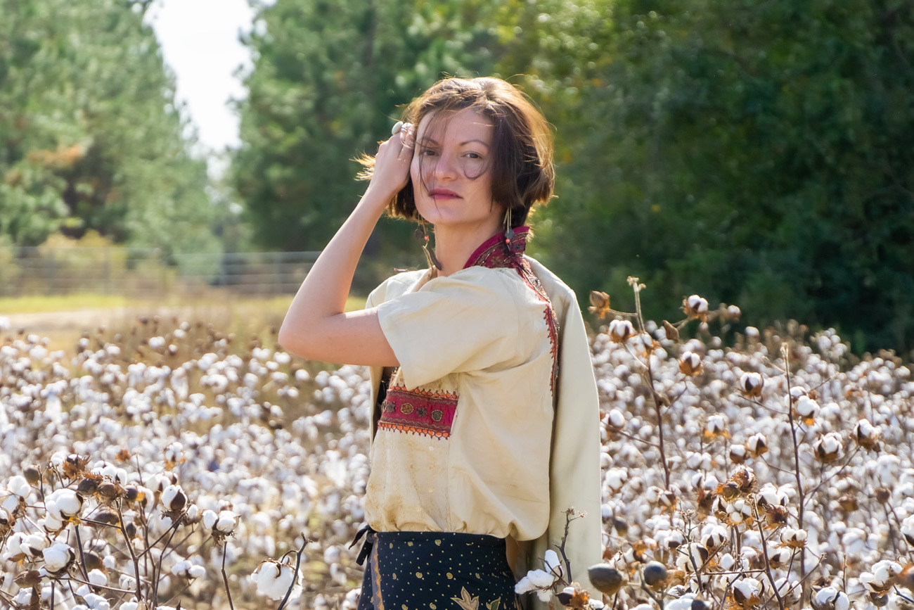 A woman standing in a field of cotton.