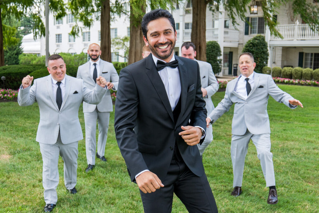 A man in a suit and tie standing next to other men.