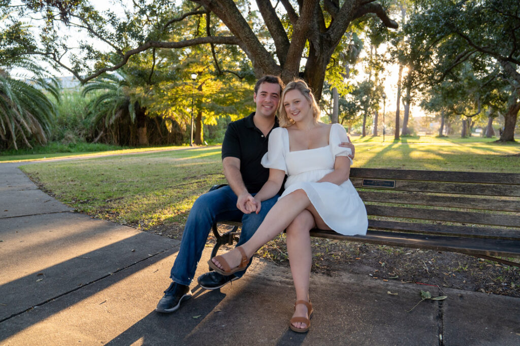 engaged couple sitting on park bench