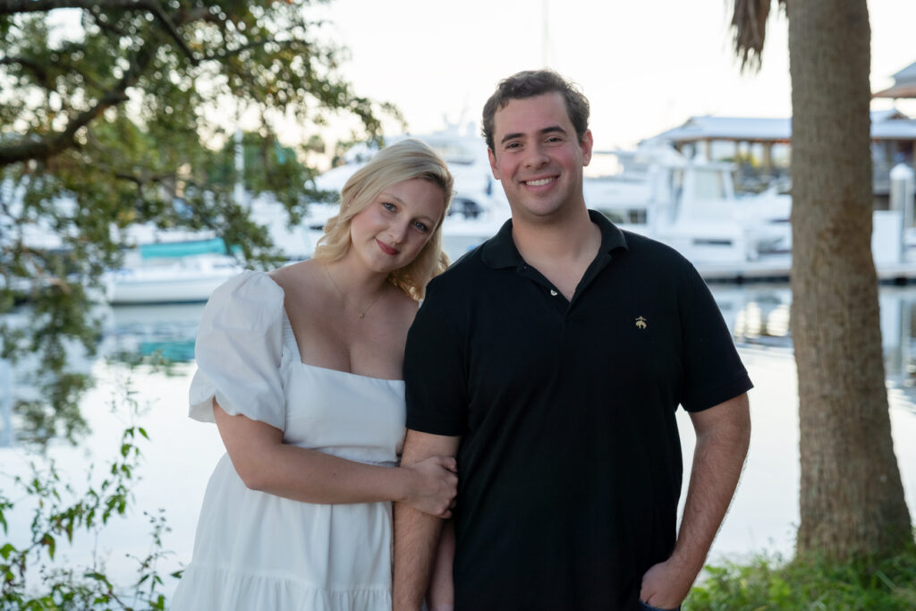 engaged couple posing near marina