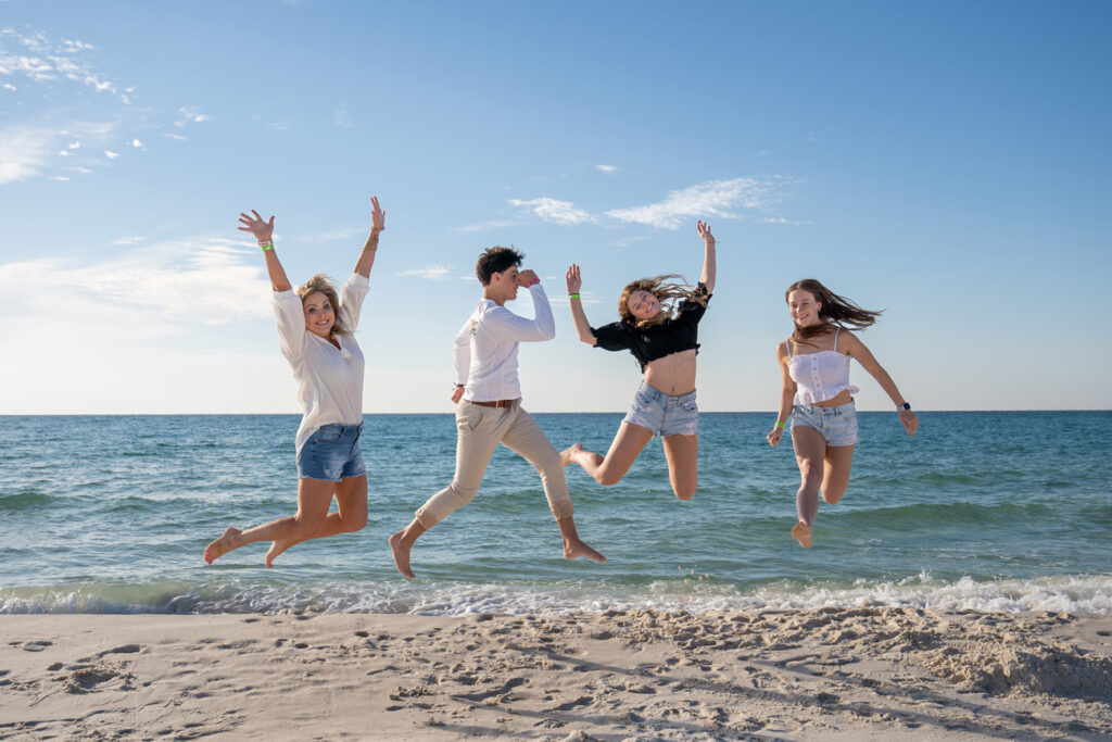group of friends jumping on pensacola beach