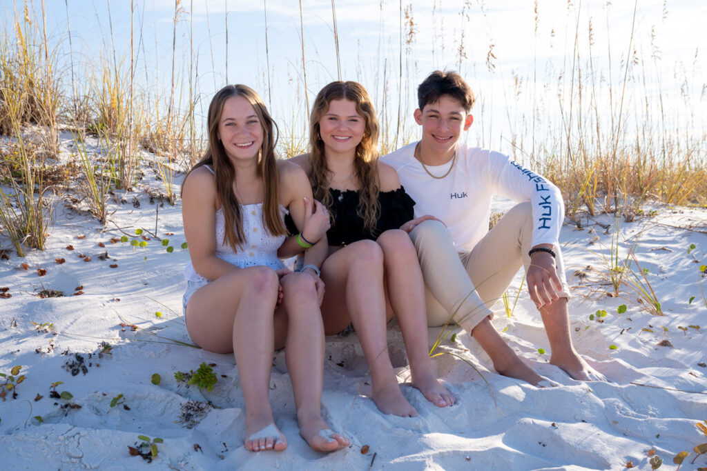 three-friends-sitting-by-sand-dunes