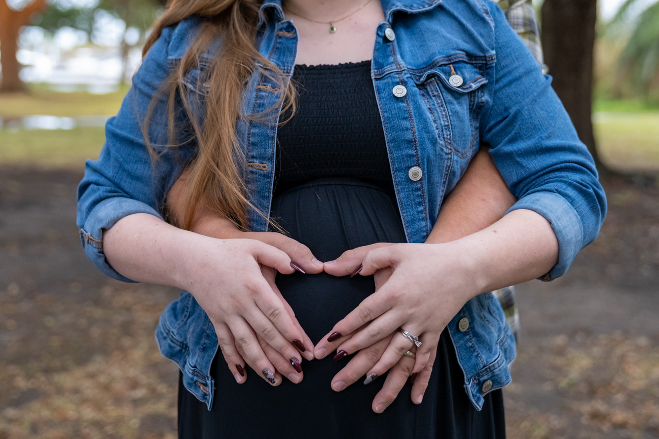 A woman holding her stomach in front of her belly.
