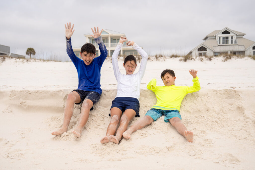 siblings playing in sand
